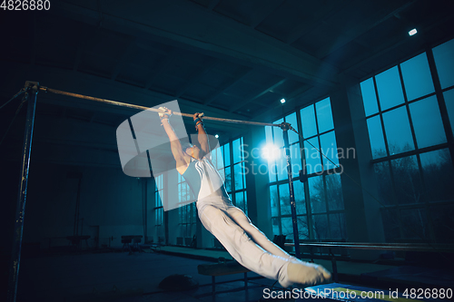 Image of Little male gymnast training in gym, flexible and active