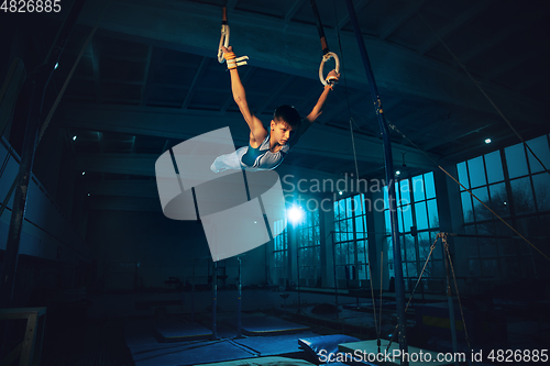 Image of Little male gymnast training in gym, flexible and active