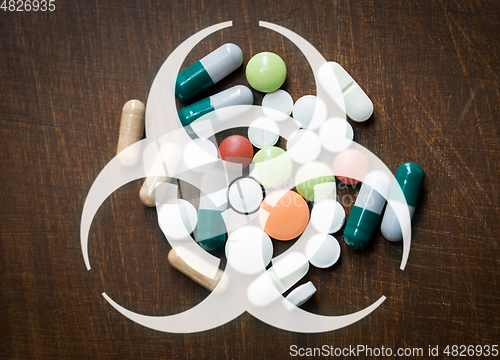 Image of biohazard caution sign over medicines on table