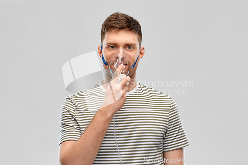 Image of unhealthy young man wearing oxygen mask