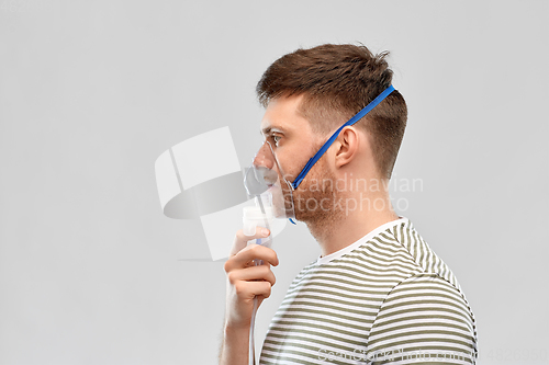 Image of unhealthy young man wearing oxygen mask