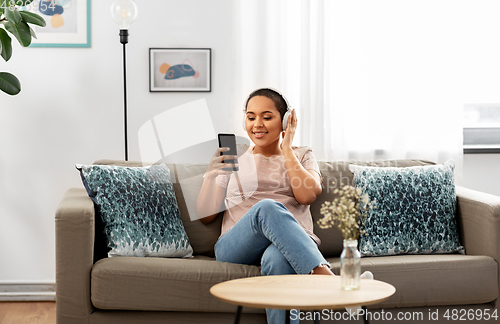 Image of woman with smartphone listening to music at home