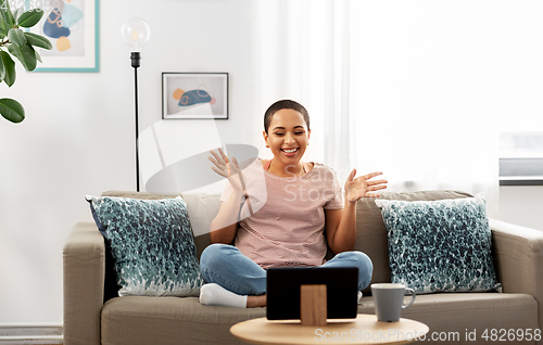 Image of african woman having video call on tablet pc