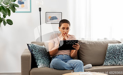 Image of african american woman with tablet pc at home