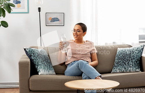 Image of african american woman with water in glass bottle