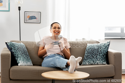 Image of african american woman with gamepad playing game