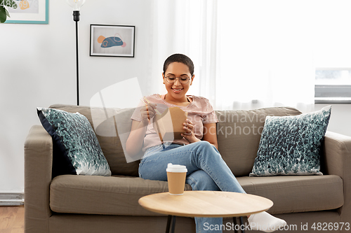 Image of african woman eating food with chopsticks at home