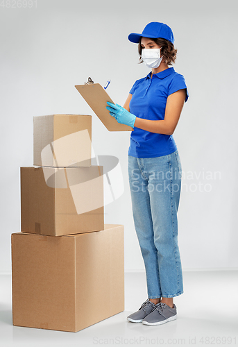 Image of delivery woman in mask with boxes and clipboard