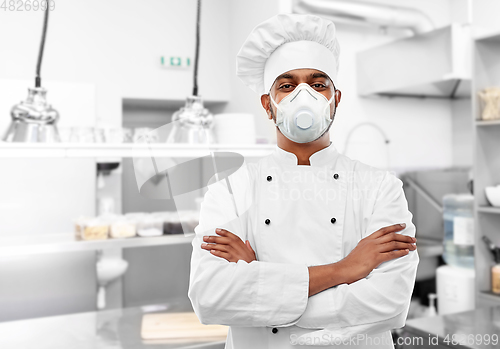 Image of male chef in respirator at restaurant kitchen