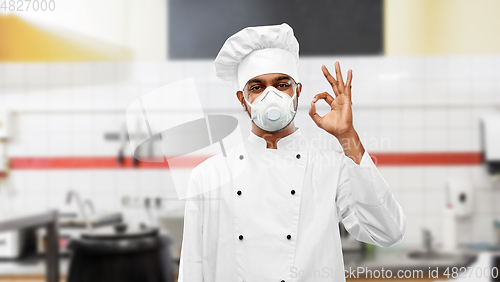 Image of chef in respirator showing ok sign at kitchen