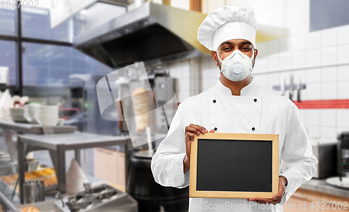 Image of chef in respirator with chalkboard at kitchen