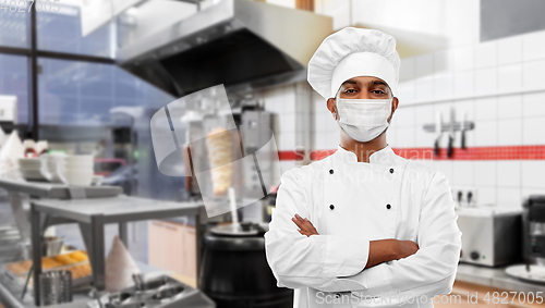 Image of male chef in face mask at restaurant kitchen