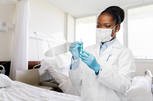 Image of african american doctor with syringe at hospital