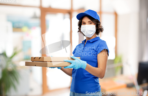 Image of delivery woman in mask with pizza boxes at office