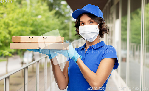 Image of delivery woman in face mask with pizza boxes