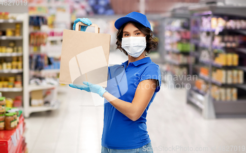 Image of delivery woman in mask with food in bag at store