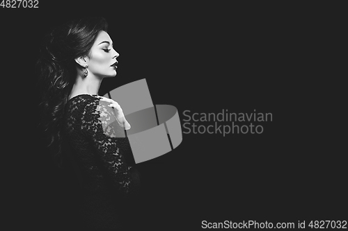 Image of beautiful young woman in lace dress on black background