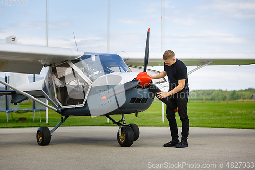 Image of young man in small plane cockpit outdoors