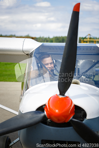 Image of young man in small plane cockpit outdoors