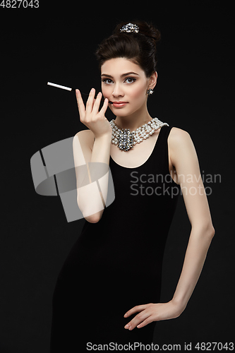 Image of beautiful young woman in retro style with cigarette