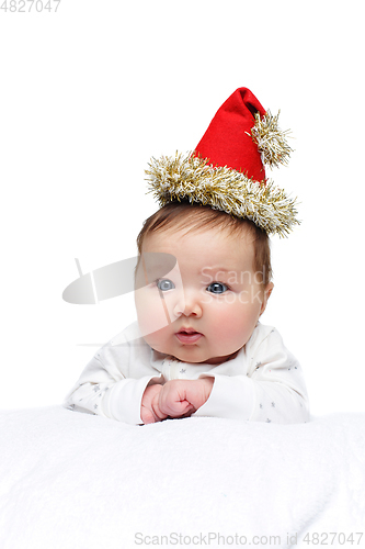 Image of beautiful baby girl in christmas hat on white blanket
