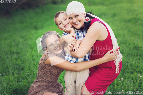 Image of mother with kids having picnic outdoors