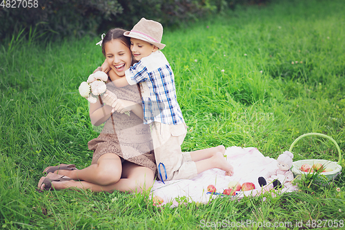 Image of Little boy and teen age girl having picnic outdoors