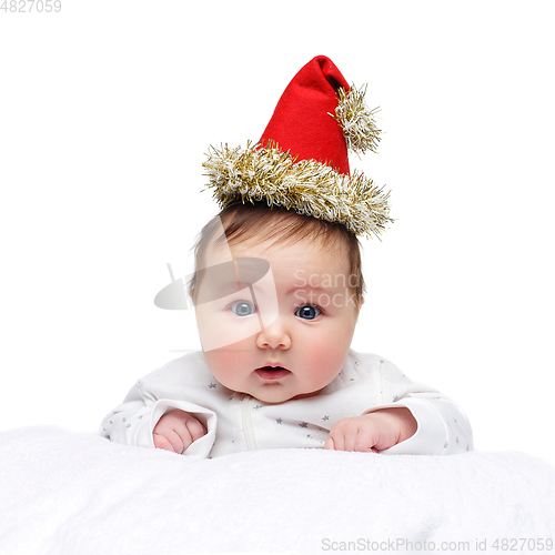 Image of beautiful baby girl in christmas hat on white blanket