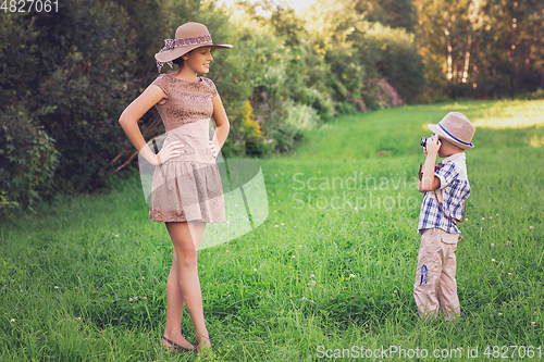 Image of handsome little boy with retro camera and girl model