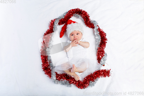 Image of beautiful baby girl in christmas hat lying