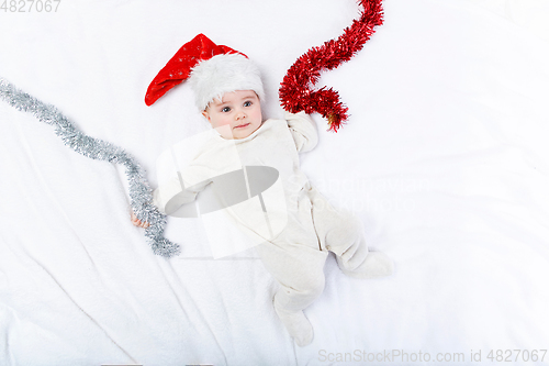 Image of beautiful baby boy in christmas hat lying