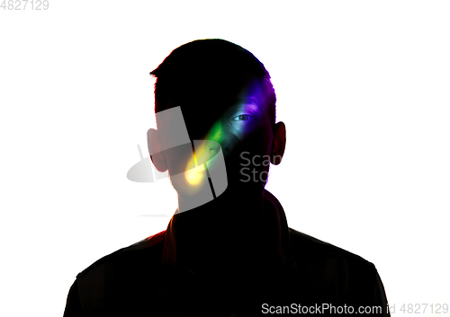 Image of Dramatic portrait of a man in the dark on white studio background with rainbow colored line