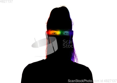 Image of Dramatic portrait of a girl in the dark on white studio background with rainbow colored line