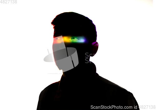 Image of Dramatic portrait of a man in the dark on white studio background with rainbow colored line