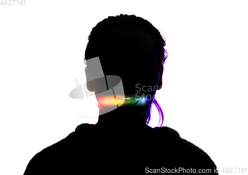 Image of Dramatic portrait of a girl in the dark on white studio background with rainbow colored line