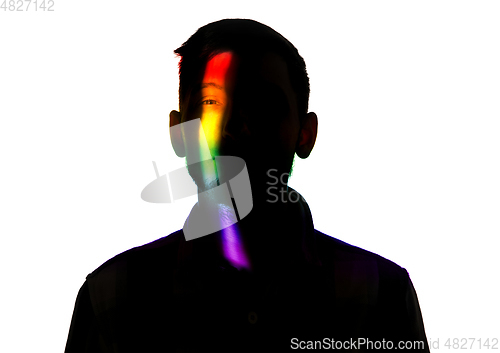 Image of Dramatic portrait of a man in the dark on white studio background with rainbow colored line