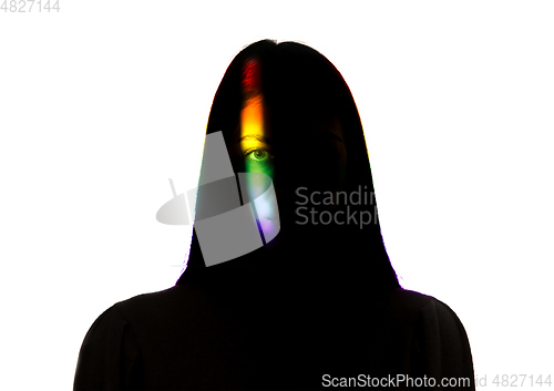 Image of Dramatic portrait of a girl in the dark on white studio background with rainbow colored line