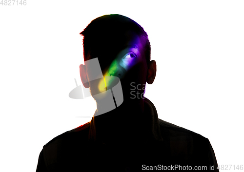 Image of Dramatic portrait of a man in the dark on white studio background with rainbow colored line