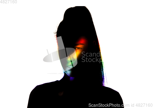 Image of Dramatic portrait of a girl in the dark on white studio background with rainbow colored line