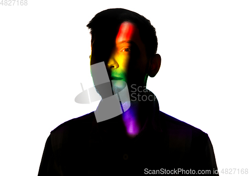 Image of Dramatic portrait of a man in the dark on white studio background with rainbow colored line