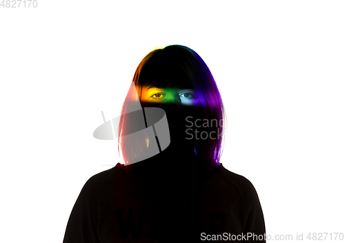 Image of Dramatic portrait of a girl in the dark on white studio background with rainbow colored line