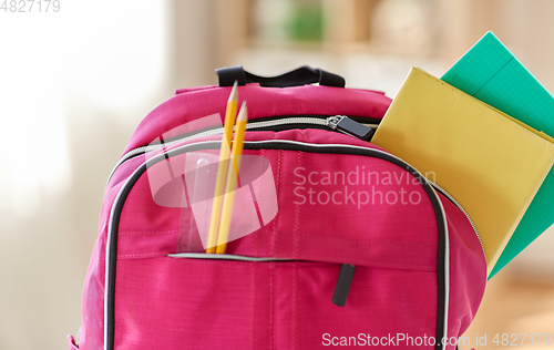 Image of pink backpack with books and school supplies