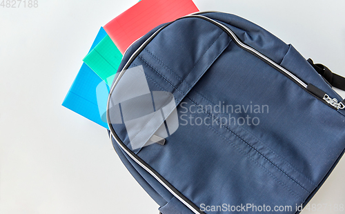 Image of school backpack with notebooks on table