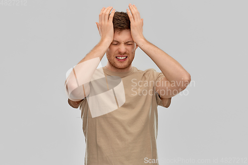 Image of unhappy man suffering from headache