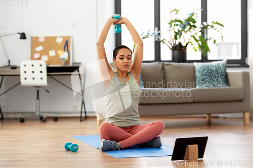 Image of woman with tablet pc and dumbbell training at home