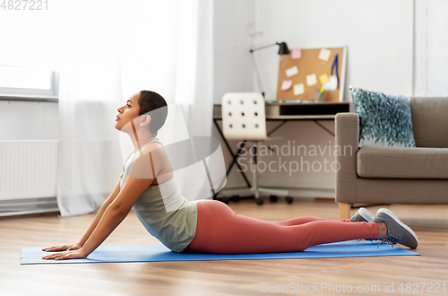 Image of woman doing cobra yoga pose at home