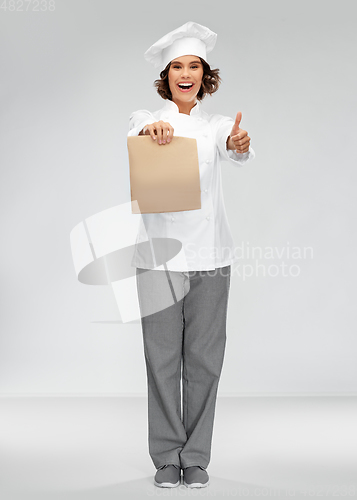 Image of happy female chef with takeaway food in paper bag