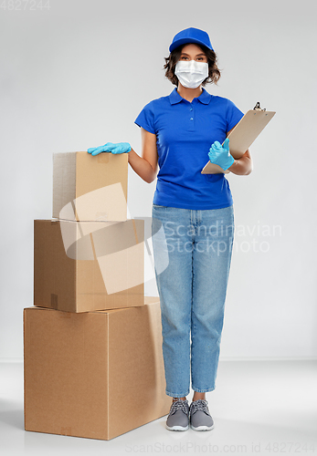 Image of delivery woman in mask with boxes and clipboard