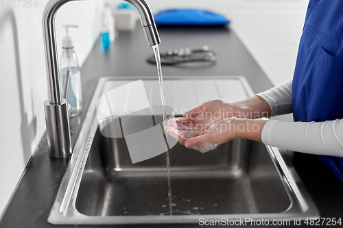 Image of doctor or nurse washing hands with liquid soap