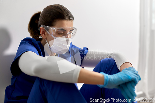 Image of sad doctor or nurse in goggles and face mask